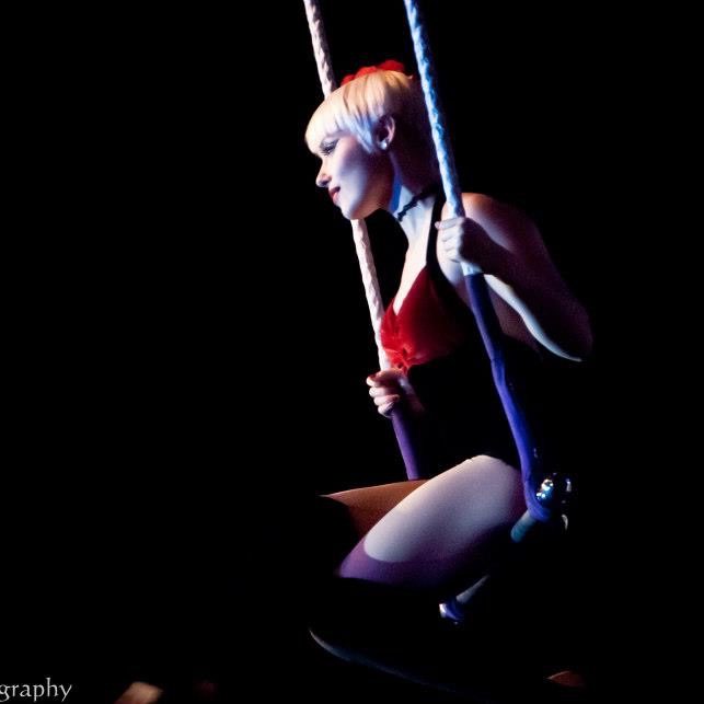 Sandra sitting on a trapeze